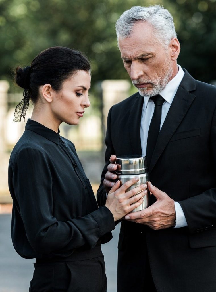 senior-man-and-attractive-woman-holding-mortuary-urn-e1636771781202.jpg